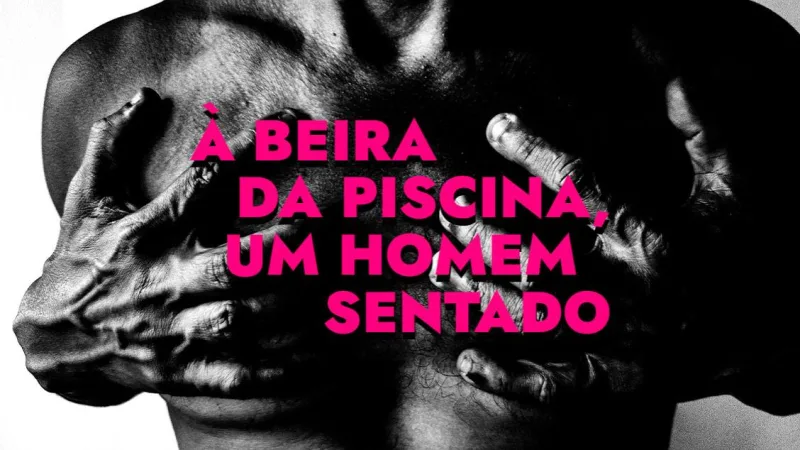 À beira da piscina, um homem sentado